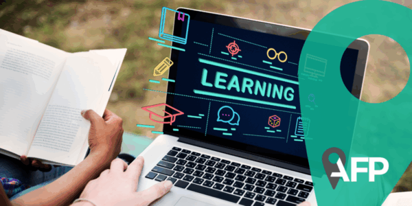 Learning Education Ideas Insight Intelligence Study Concept. Two young people hands holding computer and book, with computer screen displaying the word learning. Green graph and AFP logo on the right.
